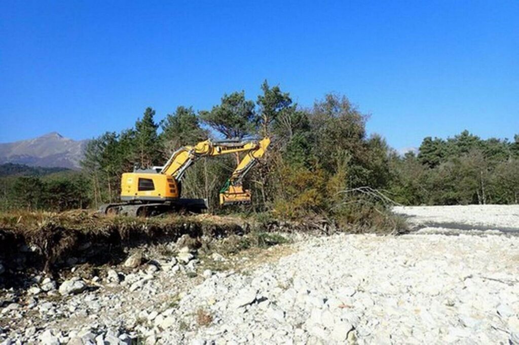photo d'un broyeur forestier monté sur une pelle mécanique sur une berge du Buëch