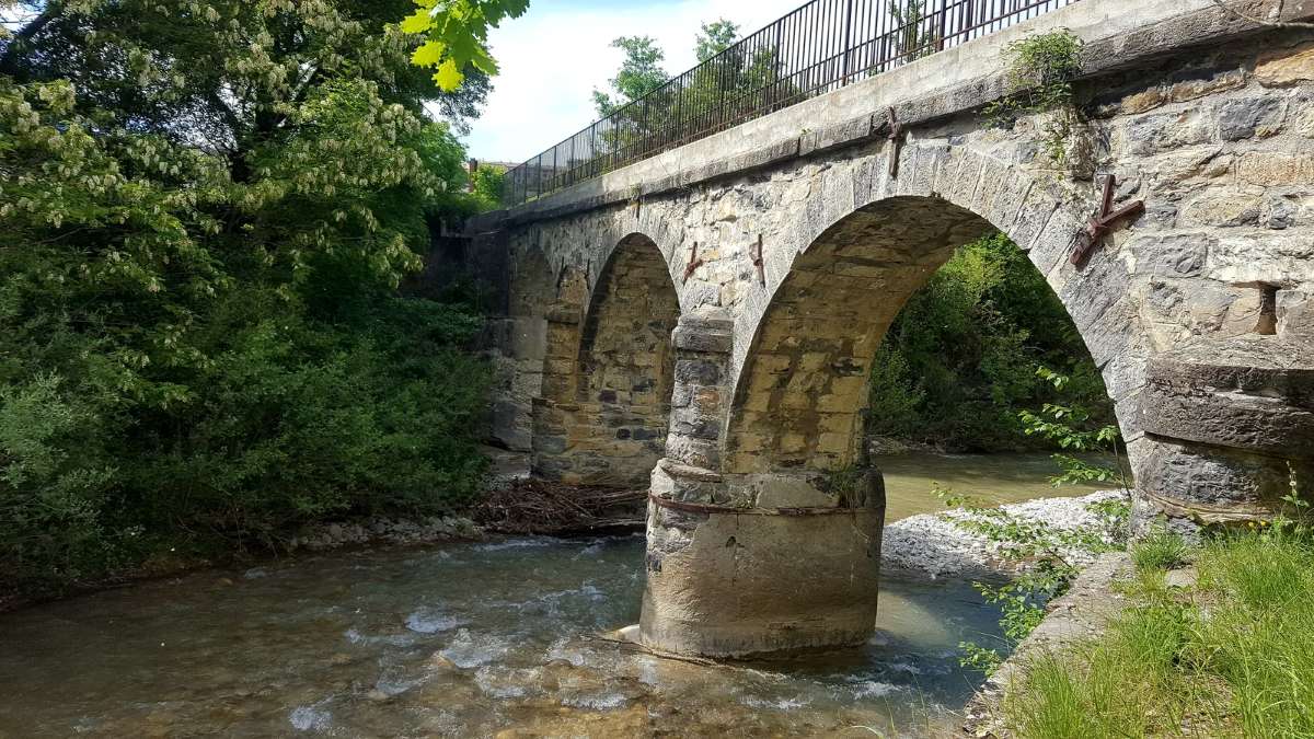 photo de l'aqueduc de l'amont vers l'aval, on voit depuis la berge rive droite trois arches de l'aqueduc et à gauche la végétation de la rive gauche, au centre de l'image l'eau de la rivière qui passe sous deux arches de l'aqueduc.